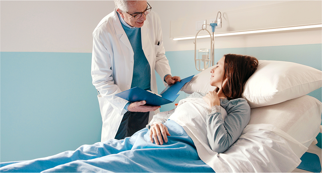 Doctor with patient in hospital bed